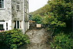 River Rushes Past Back Of Riverside Hotel